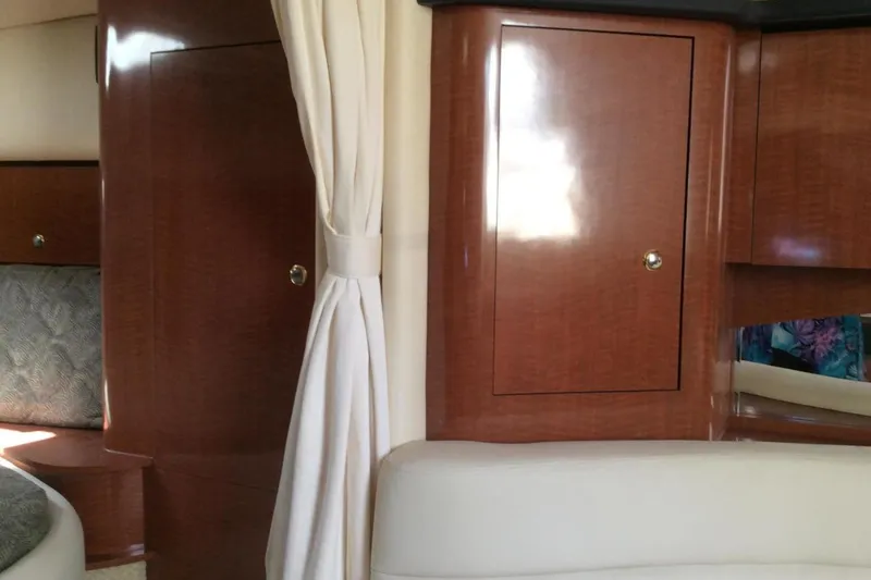 Slide: The Image of Interior of 2003 Sea Ray 320 Sundancer with wood cabinets and cream upholstery. - 12