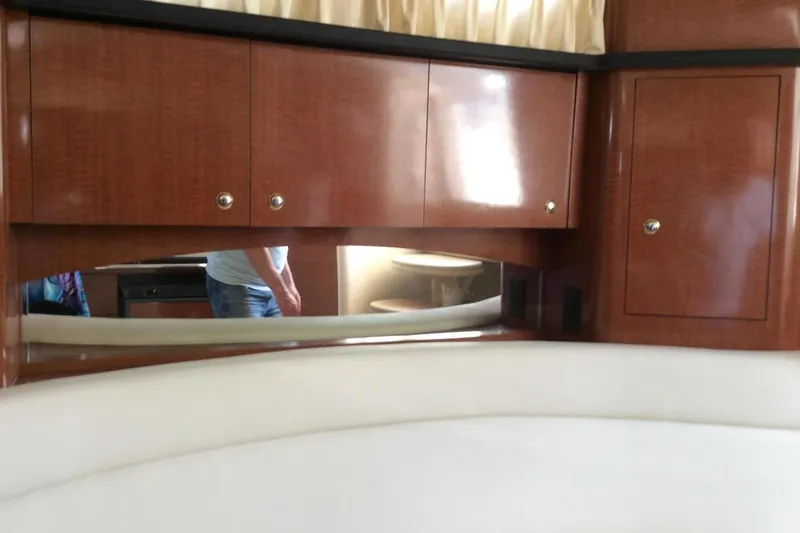 Slide: The Image of Interior of 2003 Sea Ray 320 Sundancer with wooden cabinets and white seating. - 13