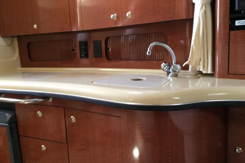 Slide: The Image of 2003 Sea Ray 320 Sundancer interior with wooden cabinets and sleek countertop. - 18