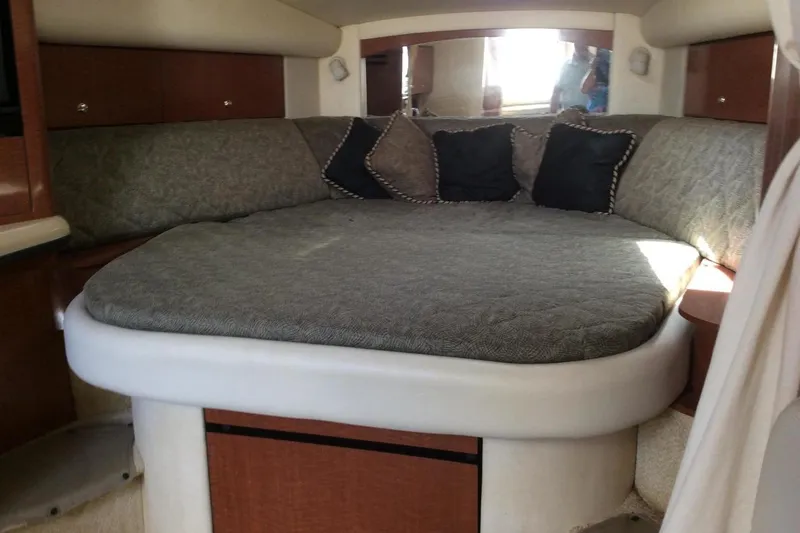 Slide: The Image of 2003 Sea Ray 320 Sundancer cabin interior with cozy bed and cushions. - 19