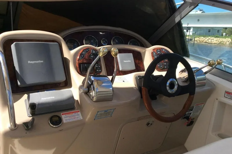 Slide: The Image of 2003 Sea Ray 320 Sundancer helm with Raymarine navigation system and steering wheel. - 22