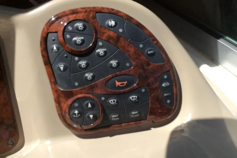 Slide: The Image of Control panel of 2003 Sea Ray 320 Sundancer boat with woodgrain finish and various buttons. - 24