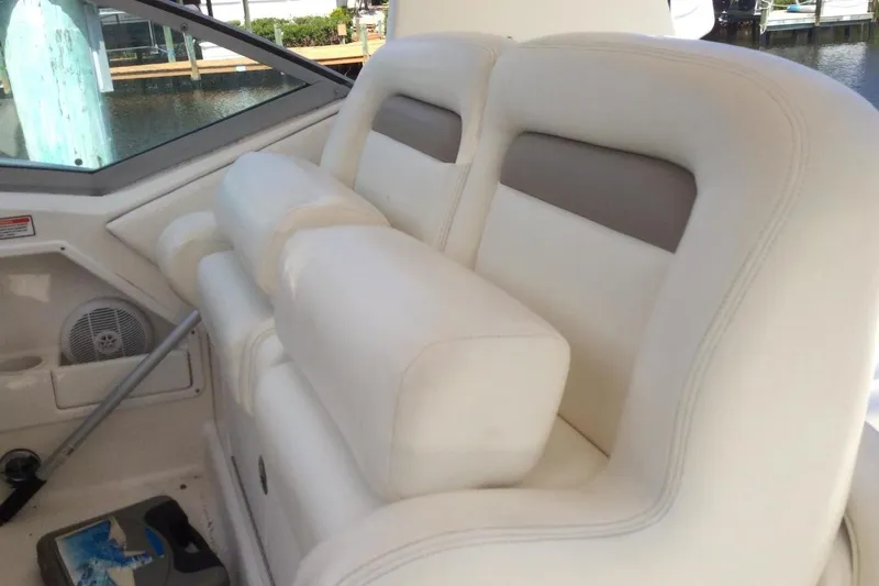 Slide: The Image of Interior seating of 2003 Sea Ray 320 Sundancer boat, featuring white cushioned seats. - 26