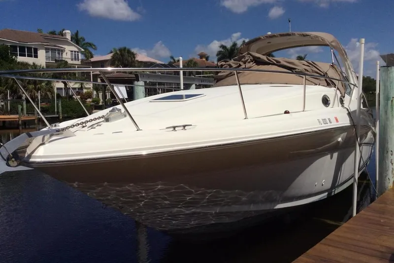 Slide: The Image of 2003 Sea Ray 320 Sundancer docked, sunny day, waterfront homes in background. - 30