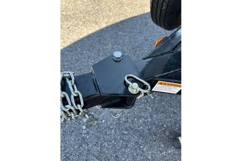 Slide: The Image of Trailer hitch of 2021 Starcraft Delta 168 Tiller with safety chains and warning label. - 29