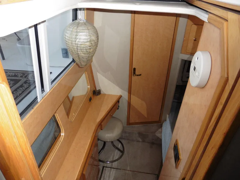 Slide: The Image of Interior of 1997 Sea Ray 440 Express Bridge with wooden cabinetry and seating area. - 10
