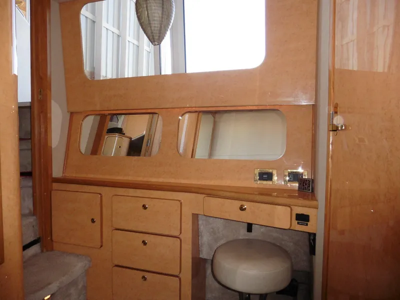 Slide: The Image of 1997 Sea Ray 440 Express Bridge interior with wooden cabinetry and mirrors. - 11