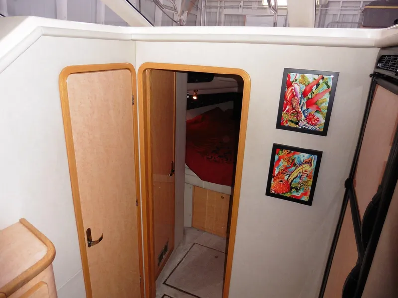 Slide: The Image of Interior of 1997 Sea Ray 440 Express Bridge with wooden doors and colorful wall art. - 12
