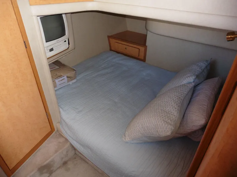Slide: The Image of Cozy cabin interior of 1997 Sea Ray 440 Express Bridge with bed and vintage TV. - 13