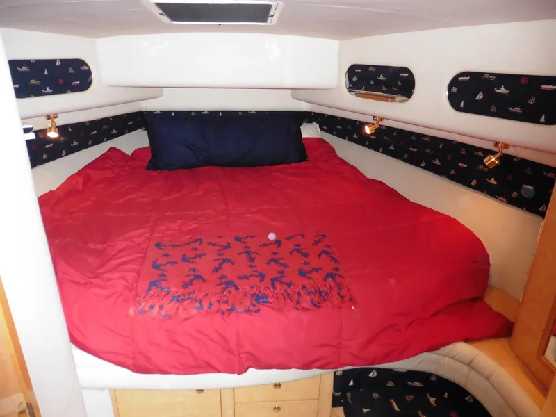 Slide: The Image of Cozy cabin interior of 1997 Sea Ray 440 Express Bridge with red bedding. - 14