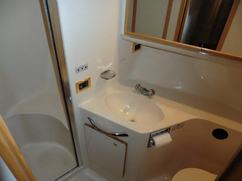 Slide: The Image of Bathroom interior of 1997 Sea Ray 440 Express Bridge yacht, featuring sink and mirror. - 15