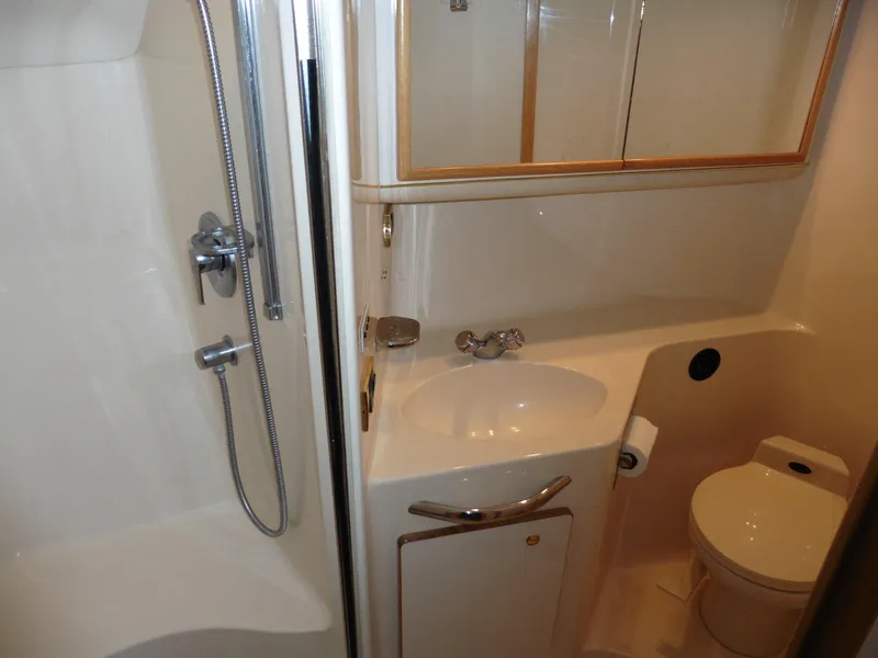 Slide: The Image of 1997 Sea Ray 440 Express Bridge bathroom with shower, sink, and toilet. - 17