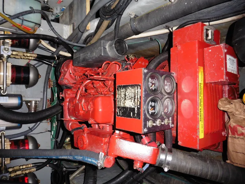 Slide: The Image of Engine compartment of a 1997 Sea Ray 440 Express Bridge with red machinery and gauges. - 23