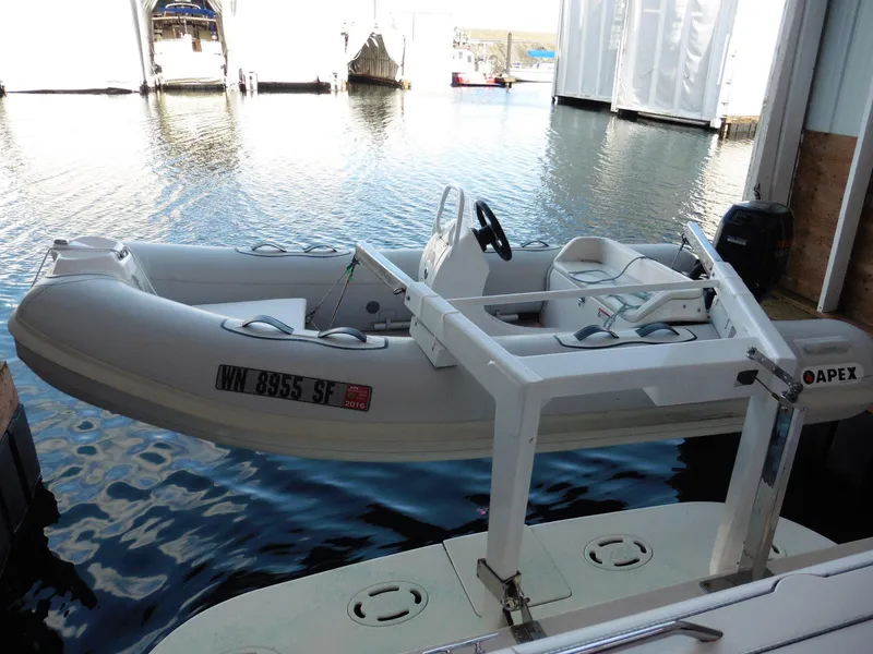 Slide: The Image of 1997 Sea Ray 440 Express Bridge with Apex inflatable boat on lift at marina. - 28