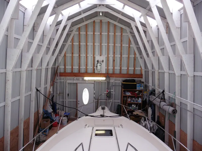 Slide: The Image of 1997 Sea Ray 440 Express Bridge in a boathouse, showcasing storage and structure. - 31