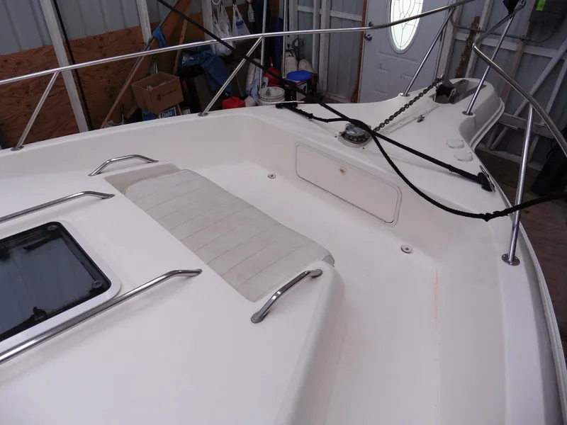 Slide: The Image of 1997 Sea Ray 440 Express Bridge deck with seating and railing in a storage area. - 32