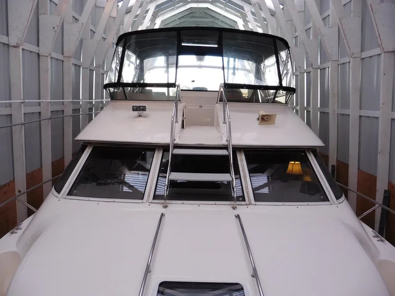 Slide: The Image of 1997 Sea Ray 440 Express Bridge yacht docked in a covered marina. - 33