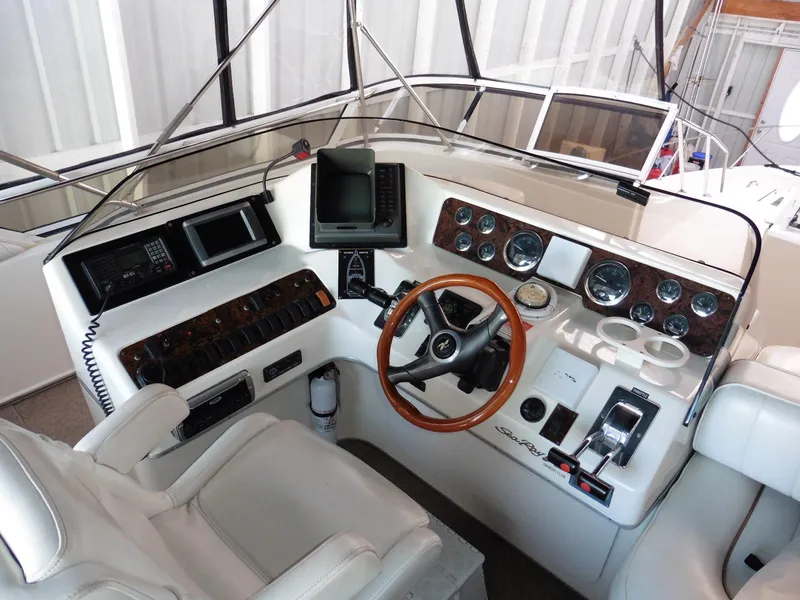 Slide: The Image of 1997 Sea Ray 440 Express Bridge helm with wood accents and navigation instruments. - 34