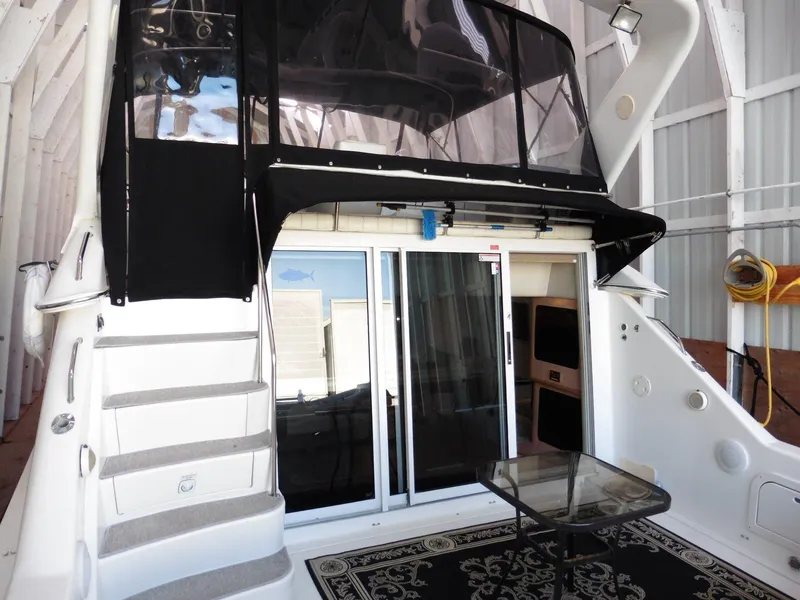 Slide: The Image of 1997 Sea Ray 440 Express Bridge yacht with stairs, glass doors, and outdoor seating. - 37