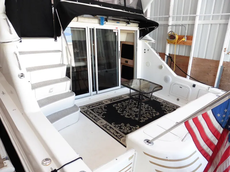 Slide: The Image of 1997 Sea Ray 440 Express Bridge yacht interior with stairs, table, and American flag. - 39