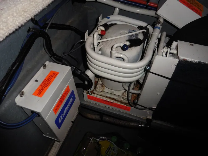 Slide: The Image of Engine compartment of 1997 Sea Ray 440 Express Bridge with visible mechanical components. - 40