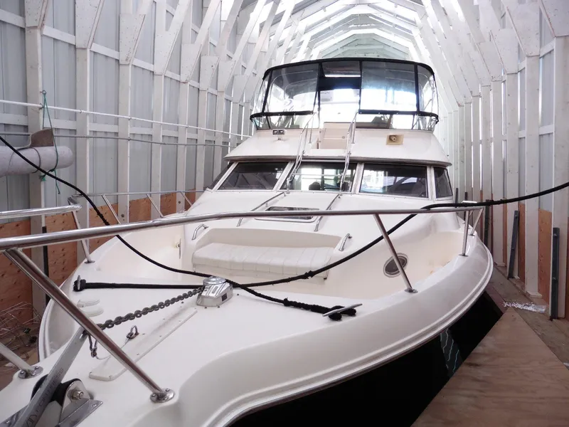 Slide: The Image of 1997 Sea Ray 440 Express Bridge yacht docked in a covered marina. - 42