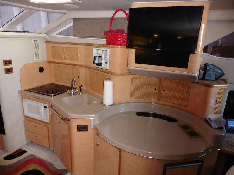 Slide: The Image of Interior of 1997 Sea Ray 440 Express Bridge yacht with kitchenette and TV. - 5