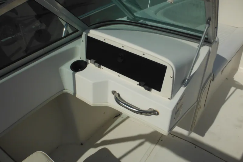Slide: The Image of 1998 Boston Whaler 20 Ventura Bowrider interior with storage compartment and cup holder. - 16