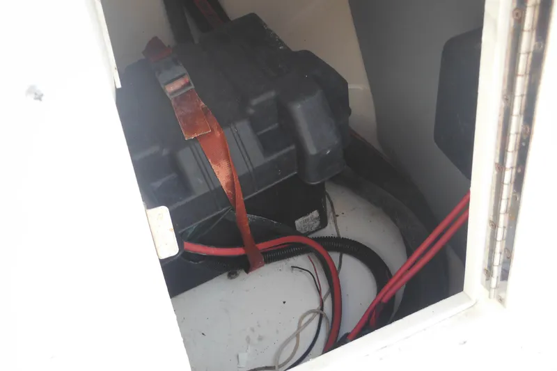 Slide: The Image of Battery compartment of 1998 Boston Whaler 20 Ventura Bowrider with cables and straps. - 31