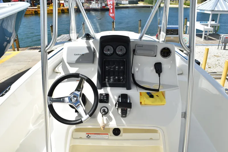 Slide: The Image of 2010 Boston Whaler 230 Dauntless boat console with steering wheel and navigation equipment. - 10