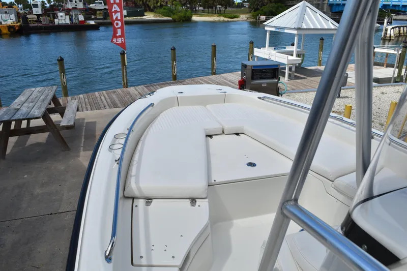 Slide: The Image of 2010 Boston Whaler 230 Dauntless boat docked by a scenic waterfront. - 16