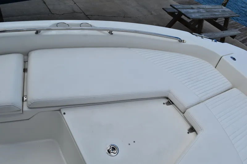Slide: The Image of Boston Whaler 230 Dauntless 2010 boat seating area with white cushions and stainless steel railing. - 18