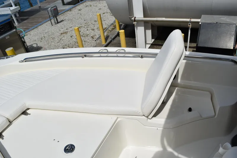 Slide: The Image of Boston Whaler 230 Dauntless 2010 boat interior with white seating and storage compartment. - 23