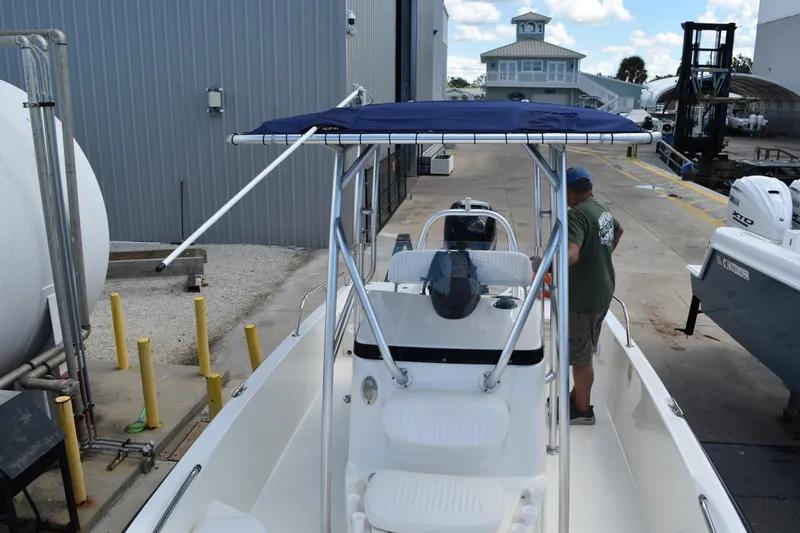 Slide: The Image of Boston Whaler 230 Dauntless 2010 boat with blue canopy in a marina setting. - 25