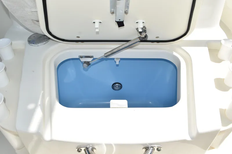 Slide: The Image of Open storage compartment on 2010 Boston Whaler 230 Dauntless boat, featuring a blue interior. - 27