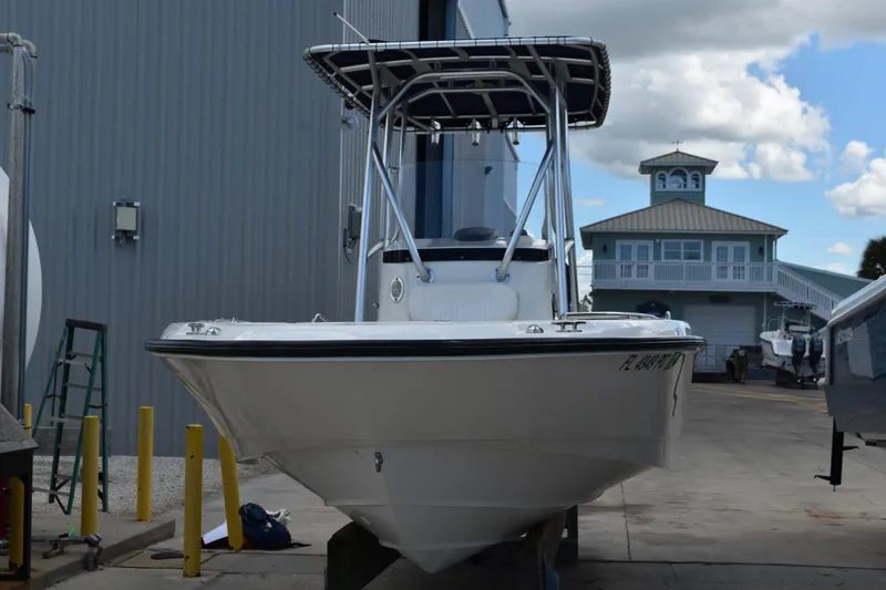 Slide: The Image of 2010 Boston Whaler 230 Dauntless boat docked near a marina building. - 3