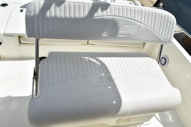 Slide: The Image of Boston Whaler 230 Dauntless 2010 boat seating with white upholstery and embossed logo. - 33
