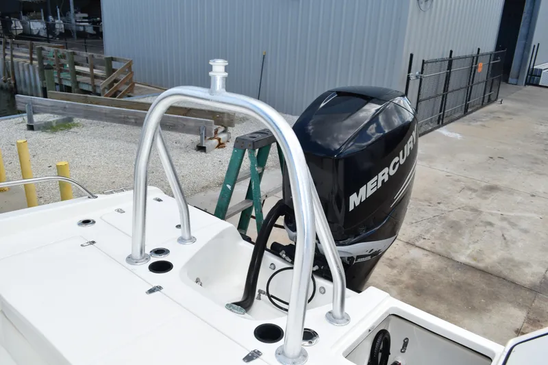 Slide: The Image of 2010 Boston Whaler 230 Dauntless with Mercury outboard engine, docked near a warehouse. - 34