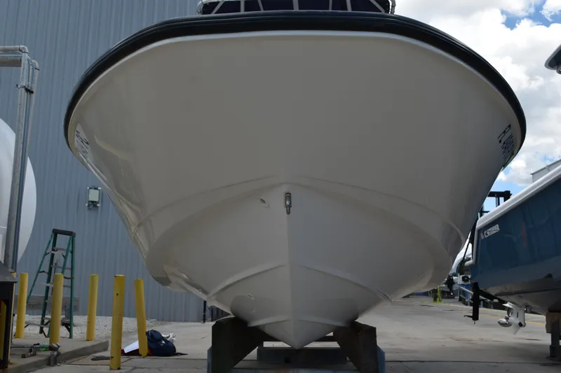 Slide: The Image of 2010 Boston Whaler 230 Dauntless boat, docked, viewed from the front, with clear sky background. - 4
