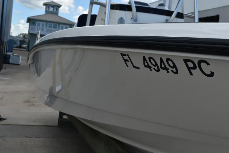 Slide: The Image of 2010 Boston Whaler 230 Dauntless boat with registration FL 4949 PC, docked near a building. - 5