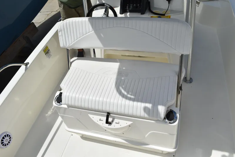 Slide: The Image of 2010 Boston Whaler 230 Dauntless boat interior with white seating and console. - 8