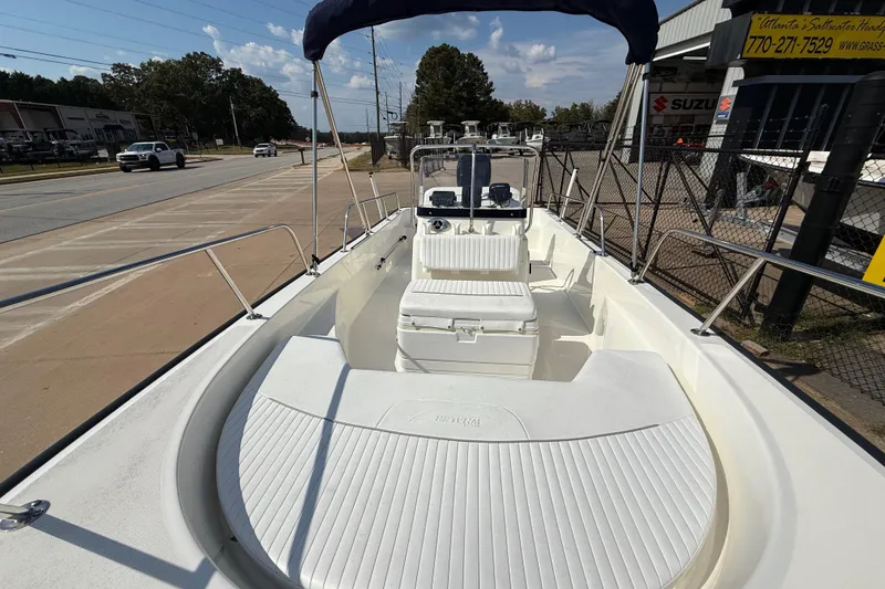 Slide: The Image of 2005 Boston Whaler 170 Montauk boat with seating and console, parked near a dealership. - 12