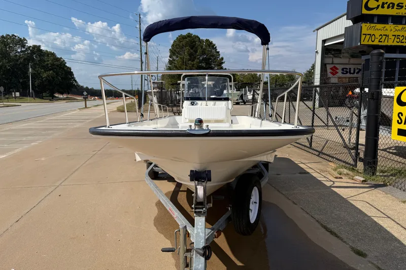 Slide: The Image of 2005 Boston Whaler 170 Montauk boat on trailer, parked outdoors under clear sky. - 3