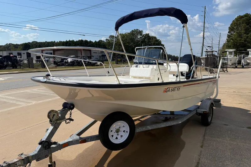 Slide: The Image of 2005 Boston Whaler 170 Montauk boat on trailer, parked outdoors under clear sky. - 4