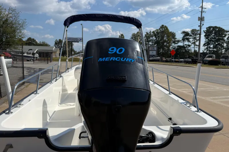 Slide: The Image of 2005 Boston Whaler 170 Montauk with Mercury 90 engine, parked outdoors under a blue sky. - 8