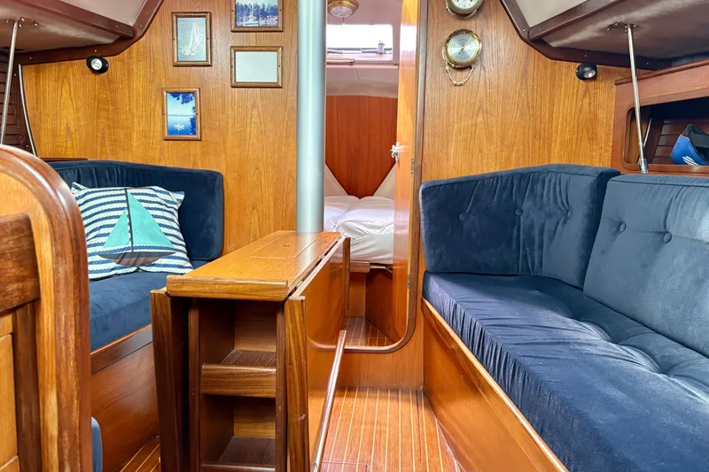 Slide: The Image of Interior of 1985 Beneteau First 345 sailboat with wood paneling and blue seating. - 10