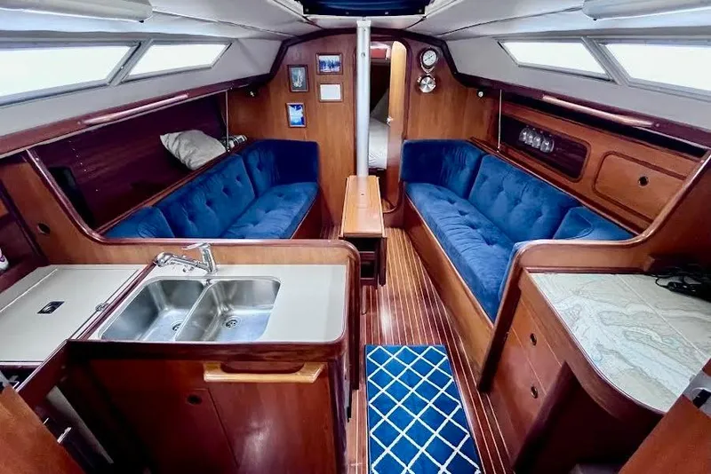 Slide: The Image of Interior of 1985 Beneteau First 345 sailboat with blue seating and wooden finishes. - 11