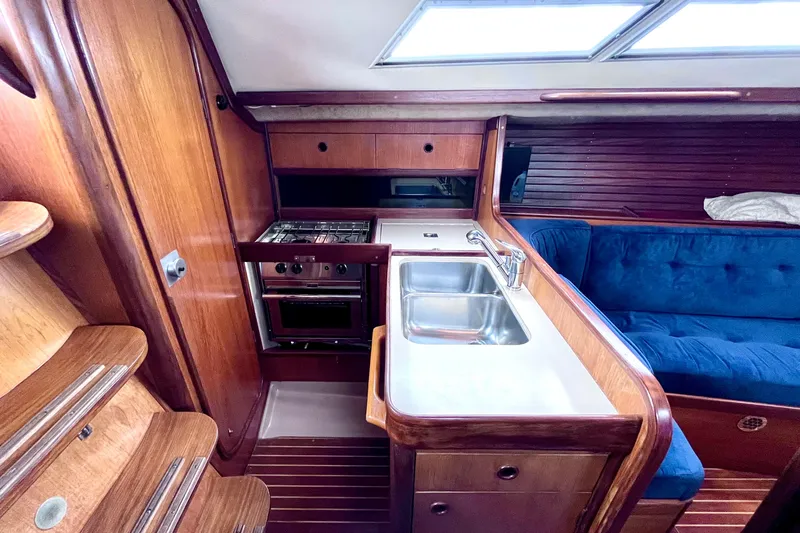 Slide: The Image of Interior of 1985 Beneteau First 345 yacht with kitchen and seating area. - 13