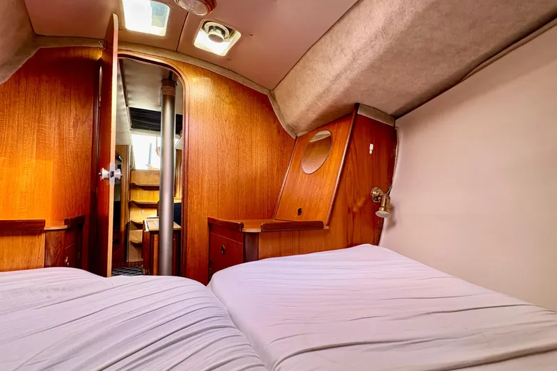 Slide: The Image of Interior cabin of 1985 Beneteau First 345 sailboat with wooden finish and cozy bedding. - 15