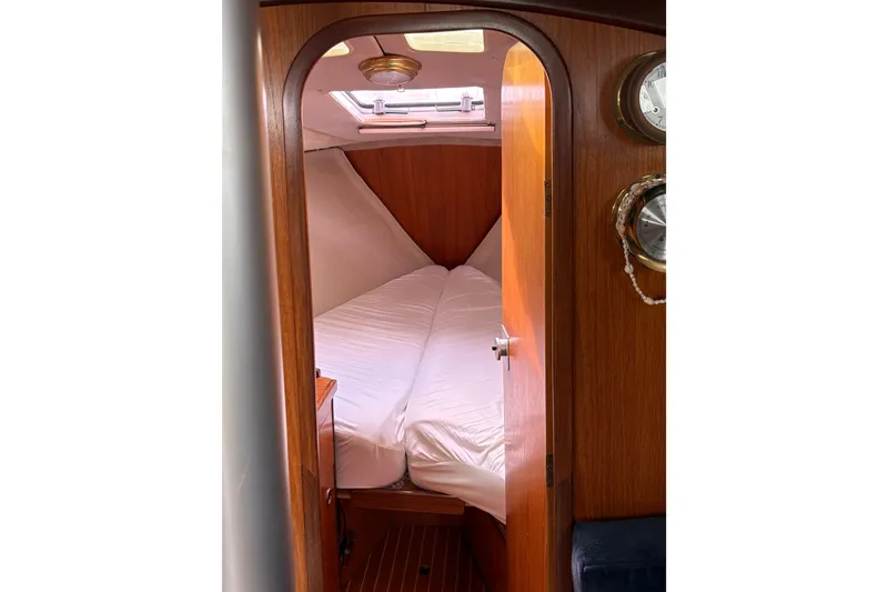 Slide: The Image of Cozy cabin interior of 1985 Beneteau First 345 sailboat with wooden finish and white bedding. - 16